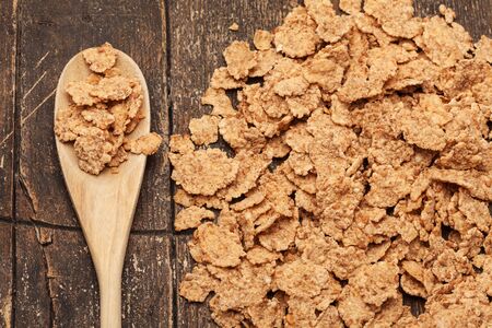 Photo of corn flakes over old wooden tableの写真素材