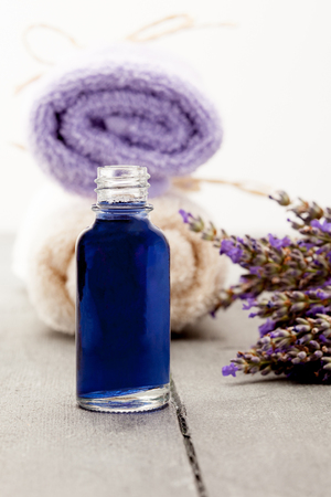 Photo of essential oil with lavender over wooden tableの写真素材
