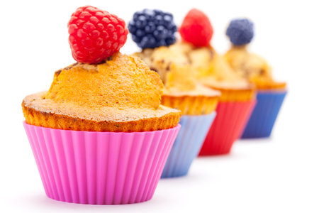 Photo of tasty cupcakes with berries over white isolated backgroundの写真素材