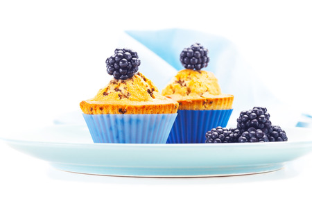 Photo of tasty muffins with blackberries over white isolated backgroundの写真素材