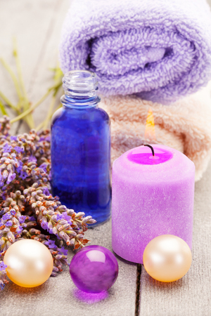 Photo of lavender oil and bath pearls over wooden tableの写真素材
