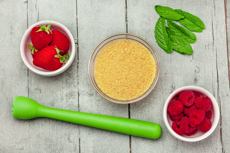 Top view of ingredients for a cocktail with berries over wooden tableの写真素材