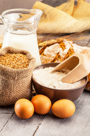 Photo of wheat grains and flour on the wooden tableの写真素材