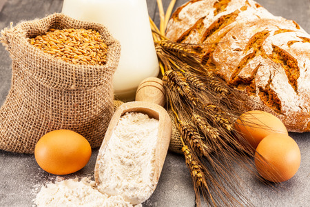 Photo of wheat grains and flour on the wooden tableの写真素材