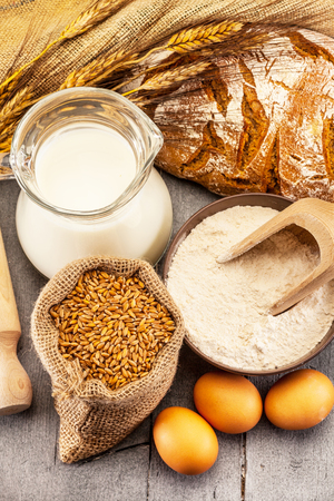 Photo of wheat grains and flour on the wooden tableの写真素材