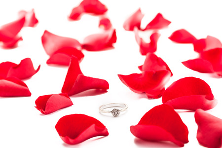 Photo of ring over red petals isolatedの写真素材