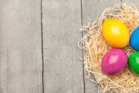 Top view of colorful easter eggs over wooden tableの写真素材