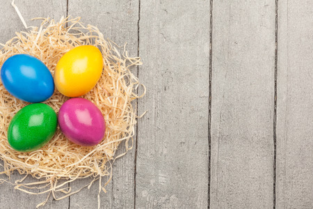 Top view of colorful easter eggs over wooden tableの写真素材