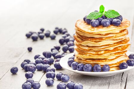 Photo of delicious pancakes with blueberries over wooden tableの写真素材