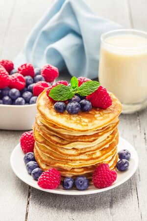 Photo  of delicious pancakes with berries over wooden tableの写真素材