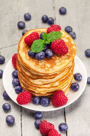 Photo  of delicious pancakes with berries over wooden tableの写真素材