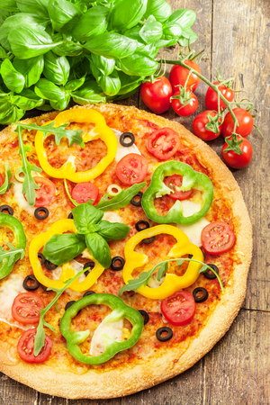 Photo of delicious pizza with paprika over wooden tableの写真素材