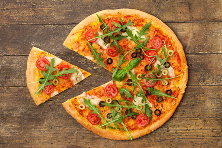 Photo of delicious pizza with rucola over wodden tableの写真素材