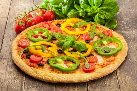 Photo of delicious pizza with paprika over wooden tableの写真素材