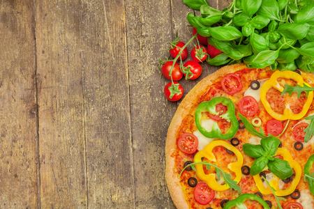 Photo of delicious pizza with paprika over wooden tableの写真素材