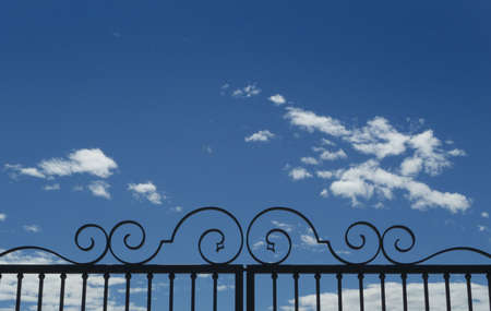 iron gate on light blue sky backgroundの写真素材