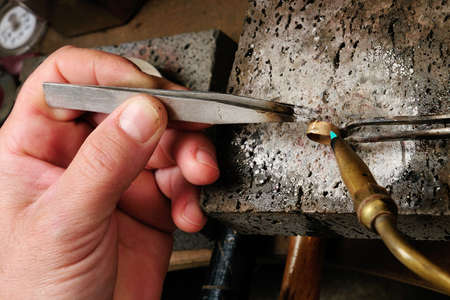 Skilled hands that create handmade jewelry with gold processing の写真素材