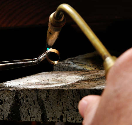 Skilled hands that create handmade jewelry with gold processing の写真素材