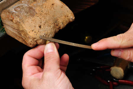 Skilled hands that create handmade jewelry with gold processing の写真素材