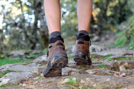 Walking on the rocks of a mountain trail with hiking boots