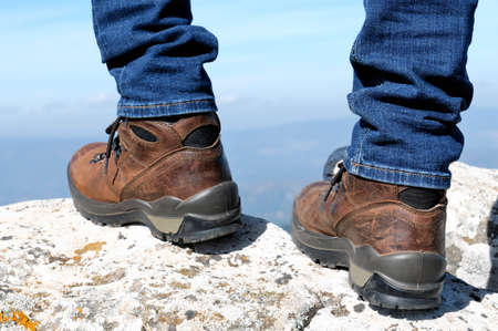Walking on the rocks of a mountain trail with hiking boots