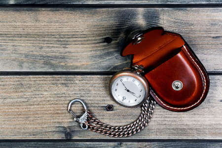 Picture of a antique pocket watch with case of old wood backgroundの写真素材