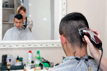 Barber shop that performs the haircut of a young boy with electric clippers.の写真素材