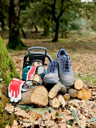 Shoes, protection gloves and glasses to safely use the chainsaw to cut wood in the forest.の写真素材