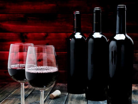 Red wine vintage in an elegant crystal goblet, on an antique wooden table.の写真素材