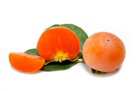 Close up of whole fresh persimmon and cut in half isolated on white backgroundの写真素材