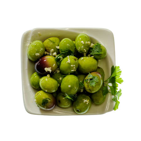 Bowl containing olives seasoned with oil, salt, parsley and garlicの写真素材