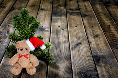 Close-up of a Christmas teddy bear on an aged wooden table.の写真素材