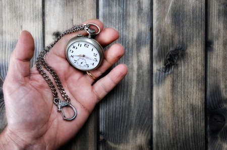 Observe the passage of time with an antique pocket watch on an old wooden backgroundの写真素材