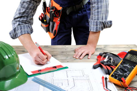Electrician technician works on the project on an aged wooden desk, isolated on white background