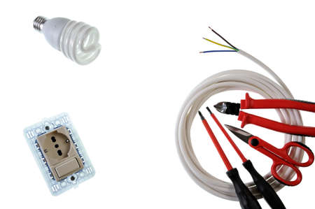 Scissors, screwdrivers, switch, socket, light bulb, cable cutter and power cable for a residential electrical installation, photographed on a white backgroundの写真素材