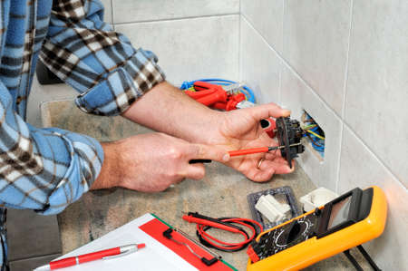 Electrician technician working on switches and sockets of a residential electrical system.