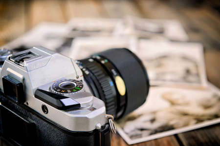 Close up of vintage photographic prints, film camera and on a rustic wooden table.の写真素材