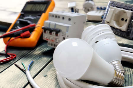 Close-up light bulbs and other components for residential electrical installation on rustic wooden tableの写真素材