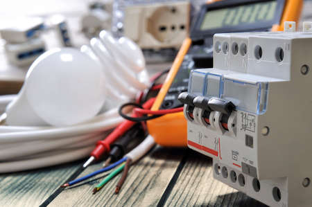 Close-up of switches for electrical panel and other components for residential electrical installation on rustic wooden tableの写真素材