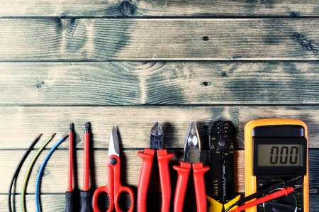Close-up of work tools for residential electrical installation on an antique wooden table with space for text / announcementの写真素材