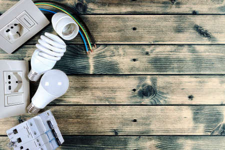 Close-up of components and elements for residential electrical installation on an antique wooden table with space for text / announcementの写真素材