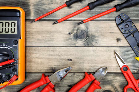 Close up of work tools for residential electrical installation on an aged wooden table. Space for text / announcement.の写真素材