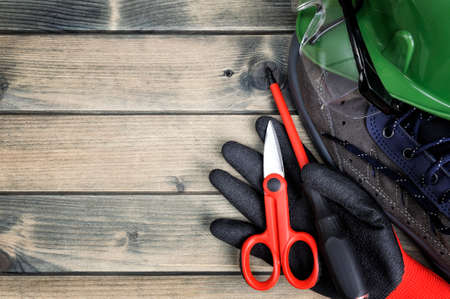 Close up of tools and workwear for electrical installation on an antique wooden table.の写真素材