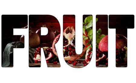 Close up of fresh ripe pomegranates and seeds on an old wood chopping boardの写真素材