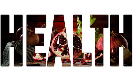 Close up of fresh ripe pomegranates and seeds on an old wood chopping boardの写真素材