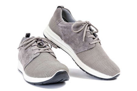 Close-up of elegant gray sport shoes for adult man photographed on white background.の写真素材