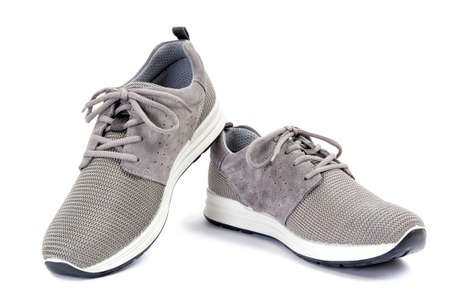 Close-up of elegant gray sport shoes for adult man photographed on white background.の写真素材
