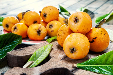 Close-up of freshly harvested fresh medlars on an antique wooden table.の写真素材