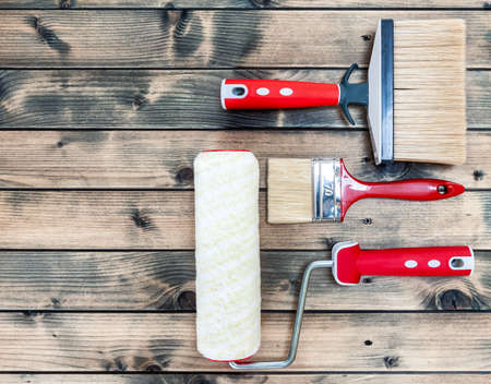 Top view of professional house painter work tools on an antique wooden table