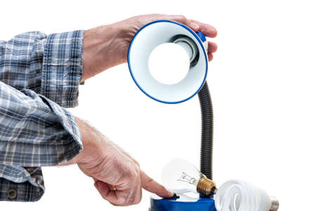 Technical electrician to work presses the switch of the table lamp with a new LED bulb installed in a residential electrical system.の写真素材